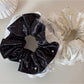 Close-up of Gifty polka dot scrunchie showing fabric texture and elastic band