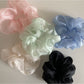 Close-up of sheer tulle fabric texture on beige scrunchie