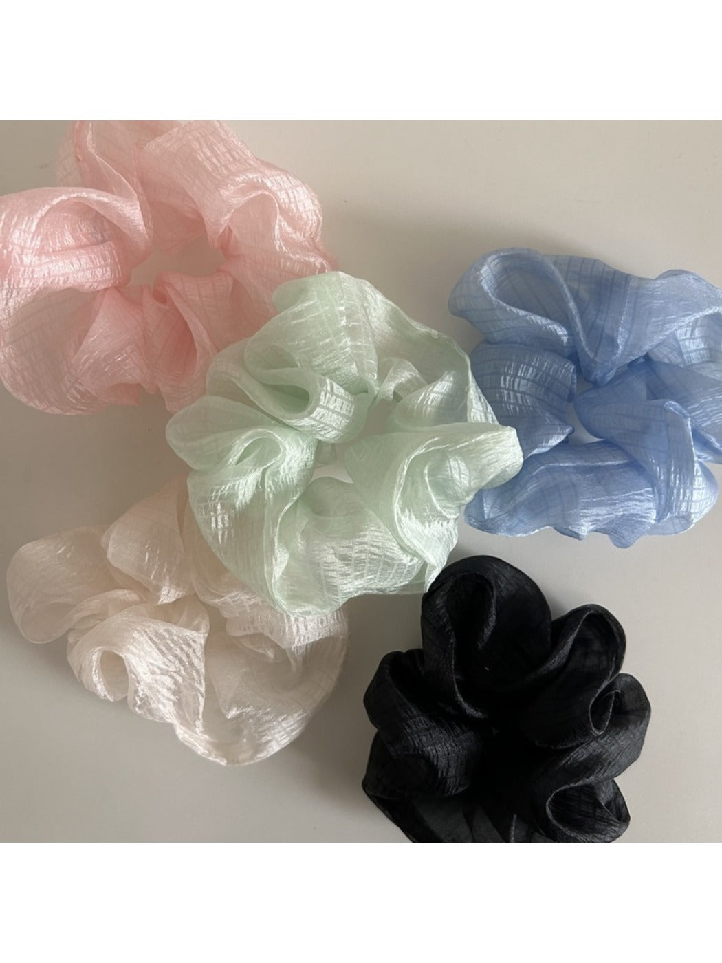 Close-up of sheer tulle fabric texture on beige scrunchie
