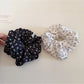 Gifty ditsy floral scrunchie styled in a ponytail on a model with light brown hair