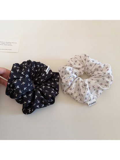 Gifty ditsy floral scrunchie styled in a ponytail on a model with light brown hair