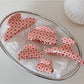 Close-up of Beau pink acetate hair clip with white polka dots on a white background