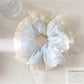 Gifty scrunchie displayed on a white background showing bow detail and fabric texture