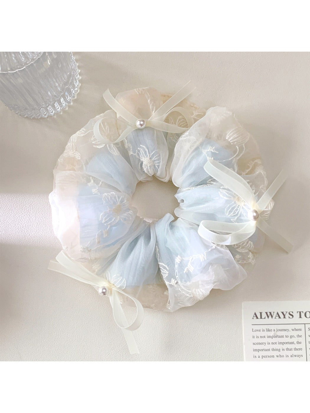 Gifty scrunchie displayed on a white background showing bow detail and fabric texture