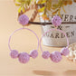Earedge raffia round ball earrings with gold-tone hooks on a neutral background