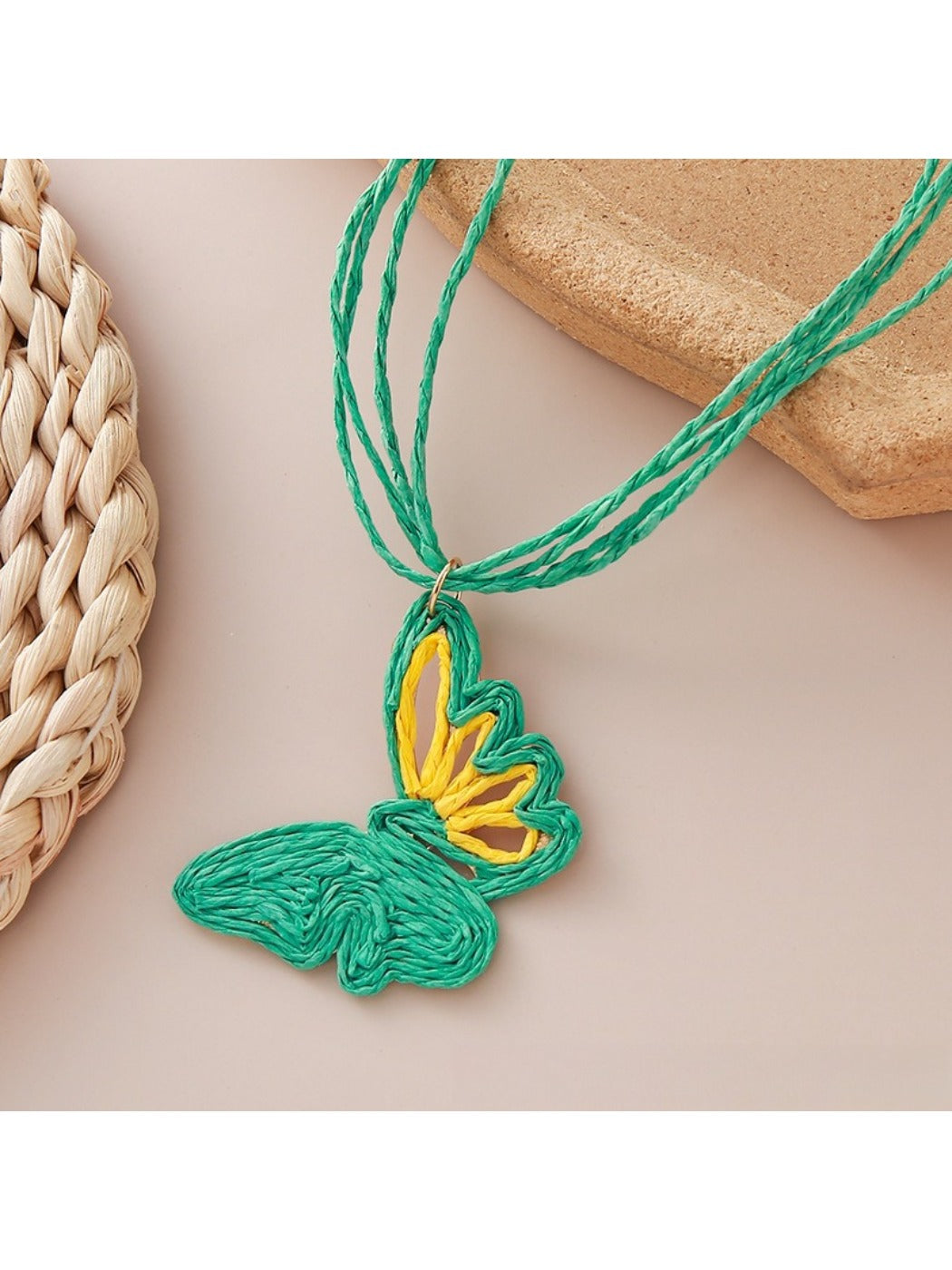 Detailed shot of raffia butterfly pendant highlighting natural fibers