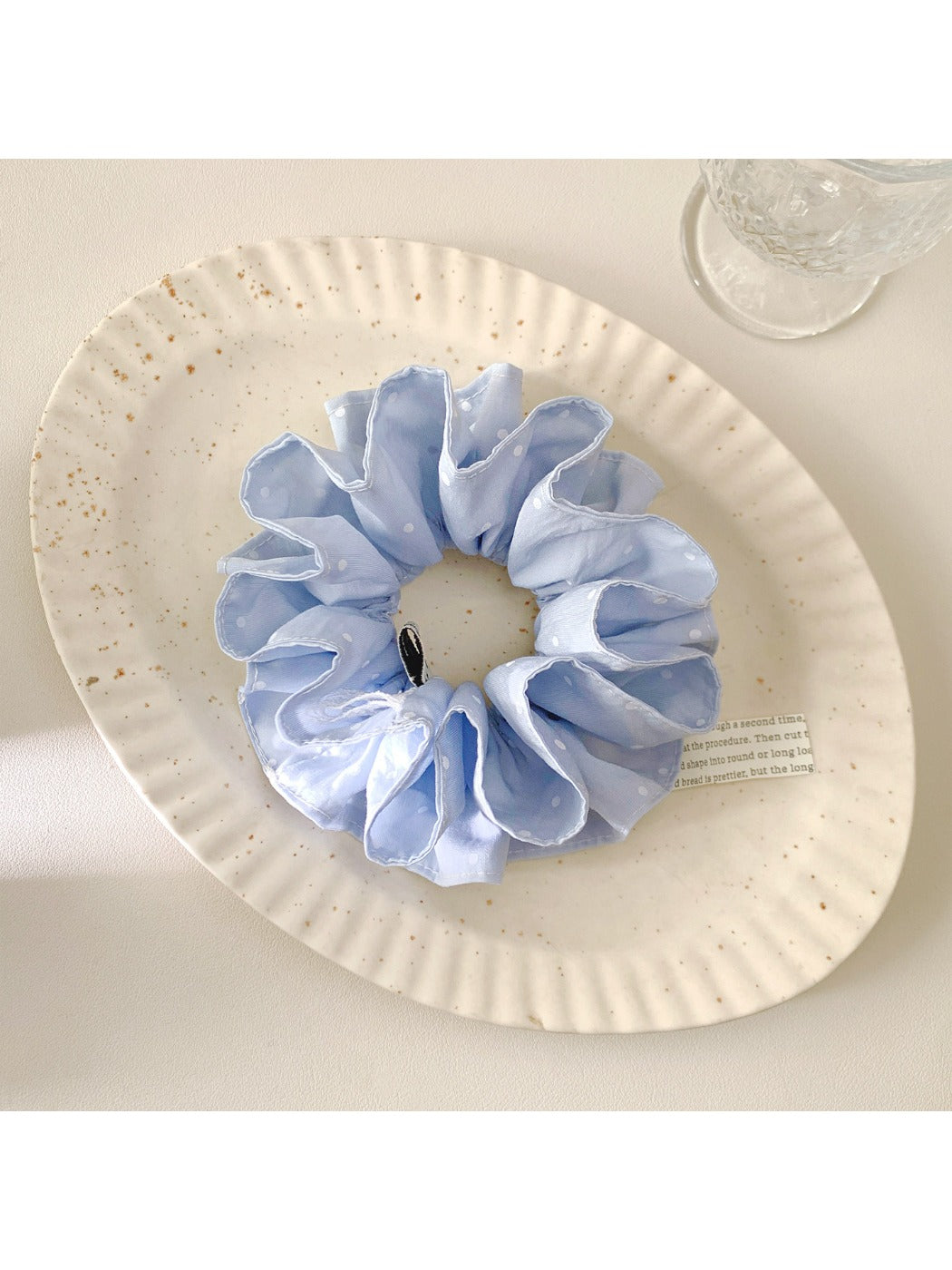 Close-up of blue scrunchie fabric with white polka dots