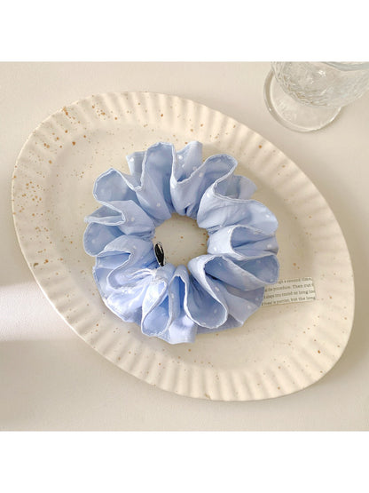 Close-up of blue scrunchie fabric with white polka dots