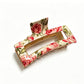 Beau rectangular hair clip placed on a white surface with visible flower details