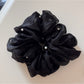 Gifty Comfy Foggy Simplicity scrunchie folded neatly on a textured cloth