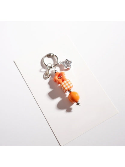 Colorful beaded star keychain displayed on a light fabric background