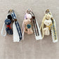 Close-up of the fabric cat keychain showing stitched facial features and texture