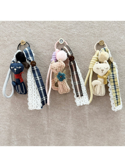 Close-up of the fabric cat keychain showing stitched facial features and texture