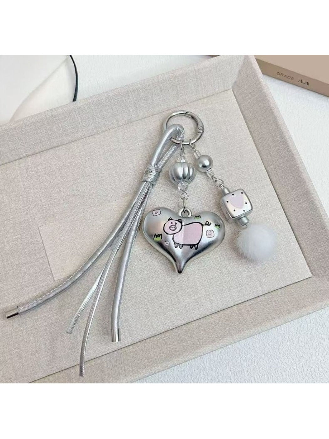 Silver heart-shaped keychain with smooth polished surface on white background