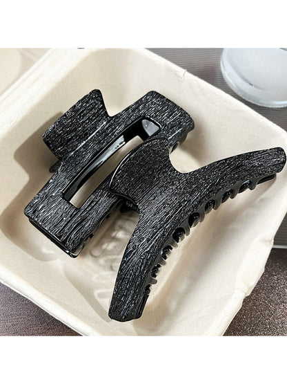 Close-up of Beau black acetate claw clip hinge and clasp mechanism