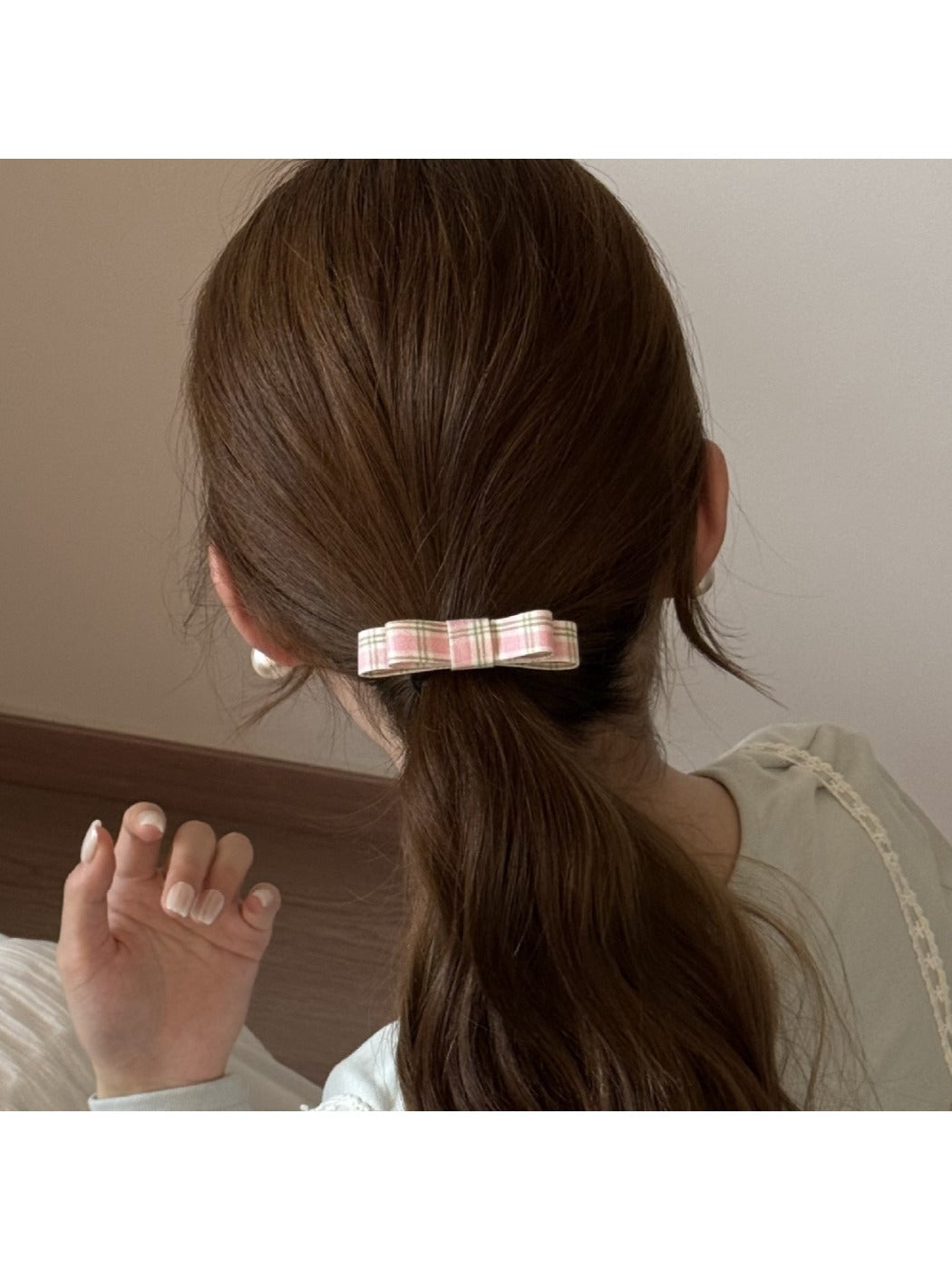 Model wearing the pink bow embellished hair tie in a ponytail hairstyle