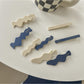 Blue and white Beau hair clip with a floral pattern on a white background