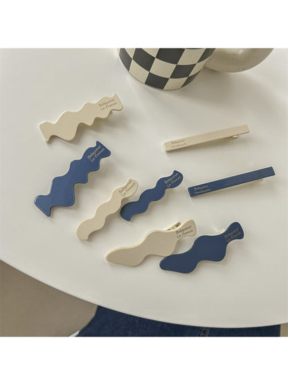 Blue and white Beau hair clip with a floral pattern on a white background