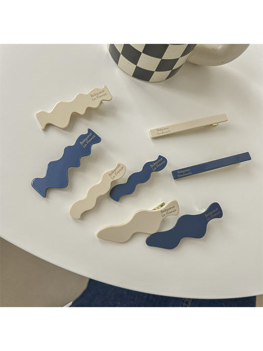 Blue and white Beau hair clip with a floral pattern on a white background