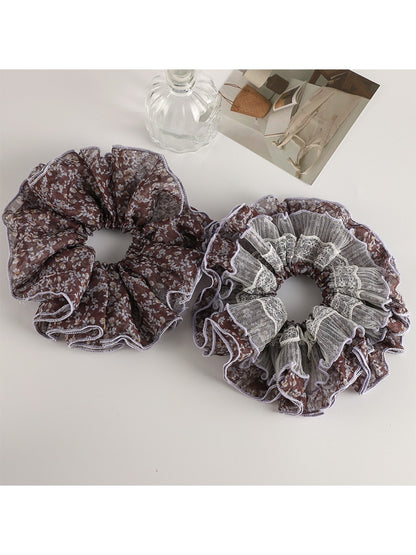 Vintage purple floral scrunchie wrapped around a ponytail on a model's hair