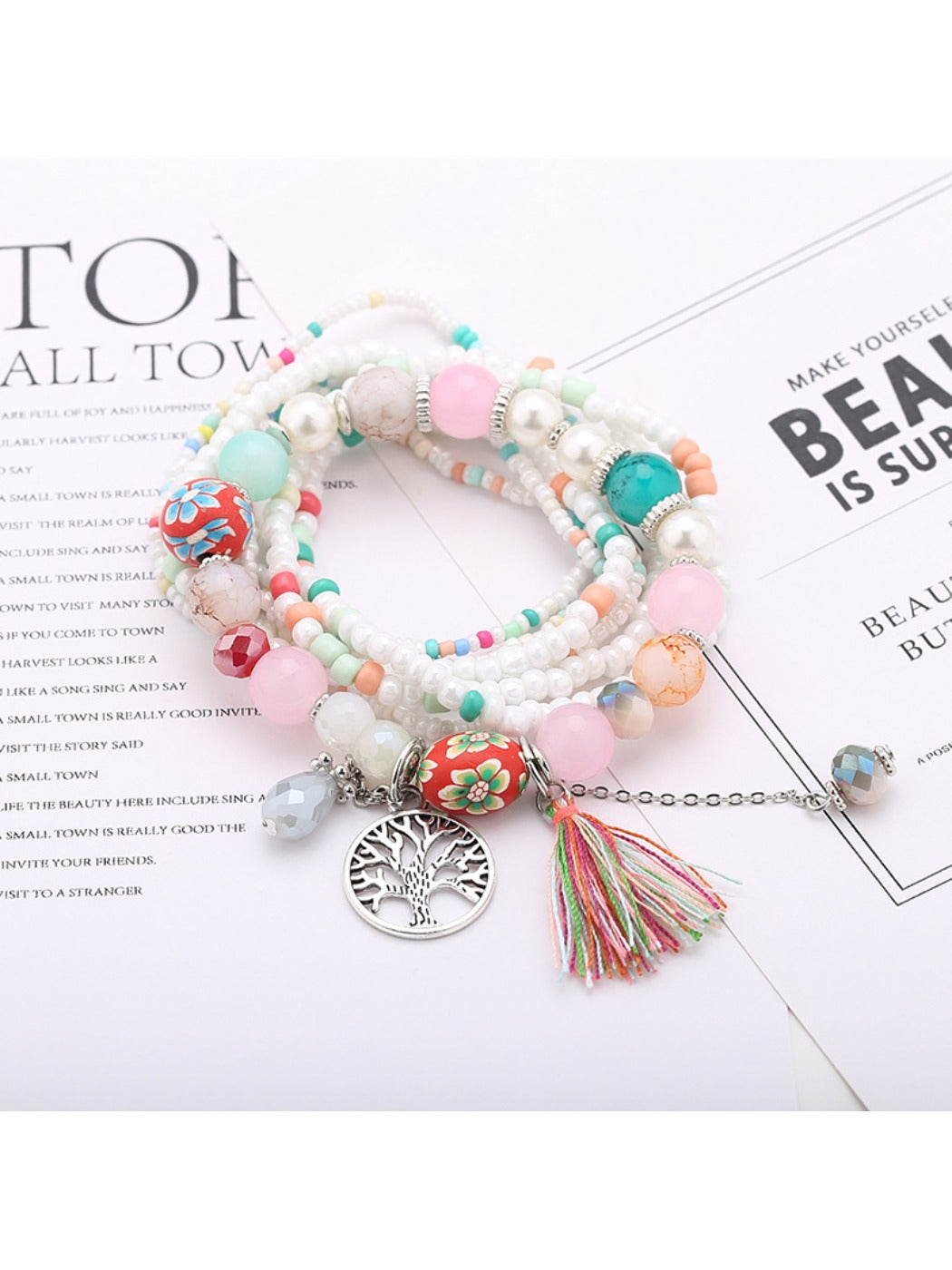 Lovra bracelet featuring tree-shaped tassel pendant and vibrant beads displayed on a hand