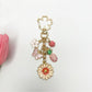 Keypus daisy charm keychain hanging from a bag zipper pull