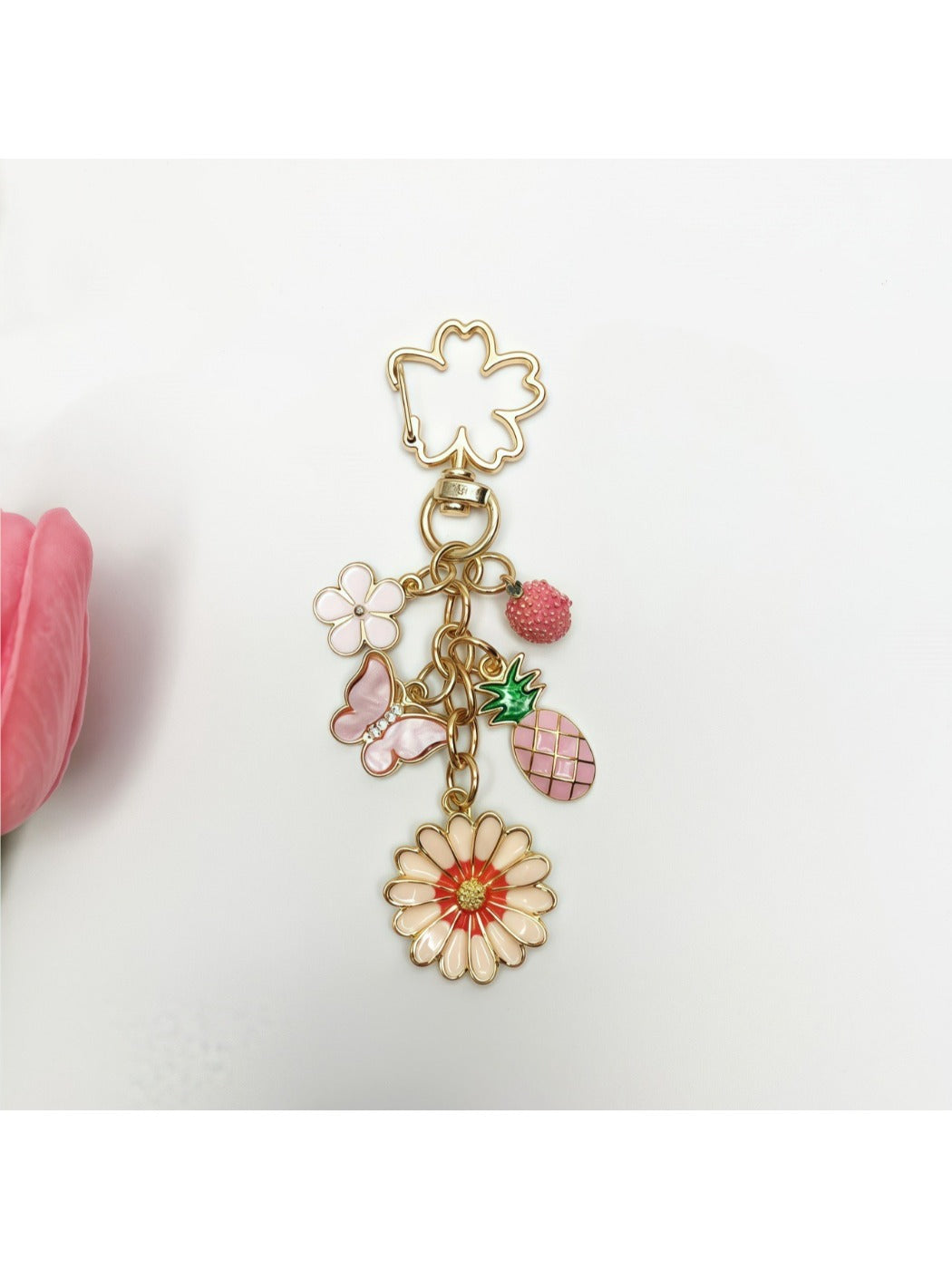 Keypus daisy charm keychain hanging from a bag zipper pull