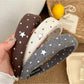 Side view of the solid color star hairband showing the star detail and band texture