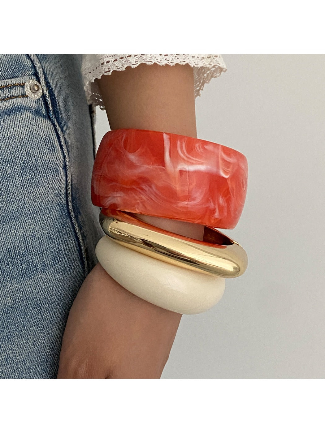 Lovra wide round bangle bracelet displayed flat with light reflections on metal