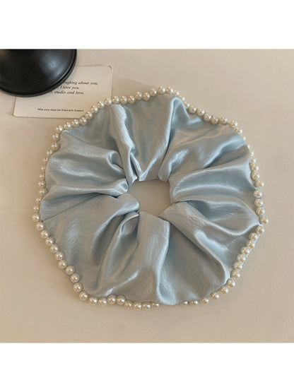 Gifty satin scrunchie with pearl beads styled in a woman's hair