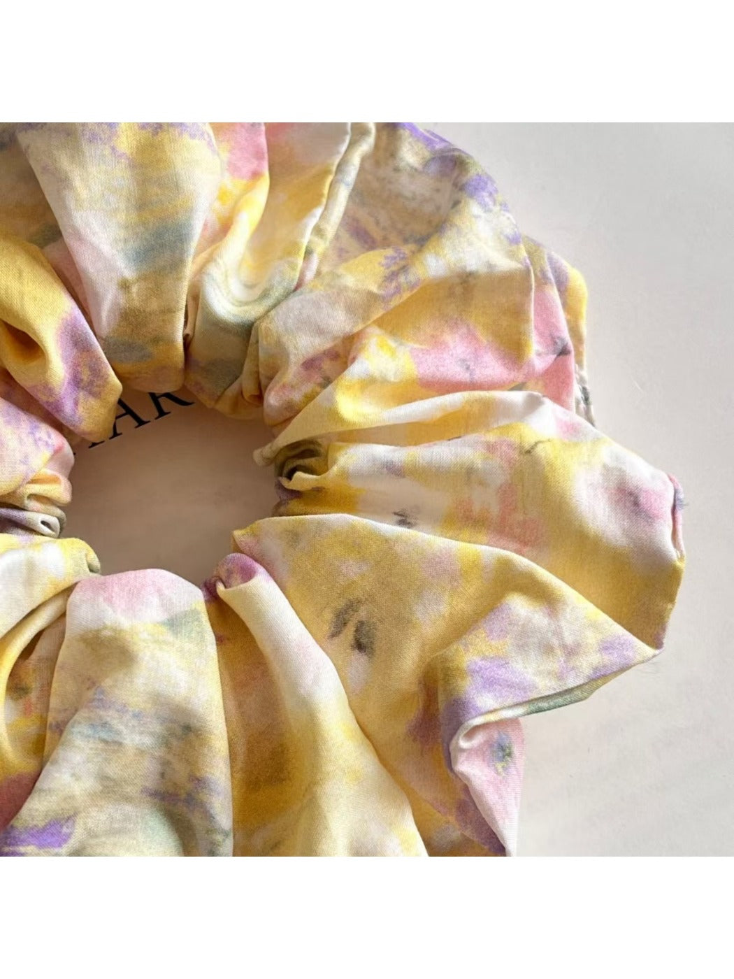 Set of oil painting style scrunchies in various bright colors displayed on white background