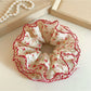 Red scrunchie with tiny white floral print on fabric