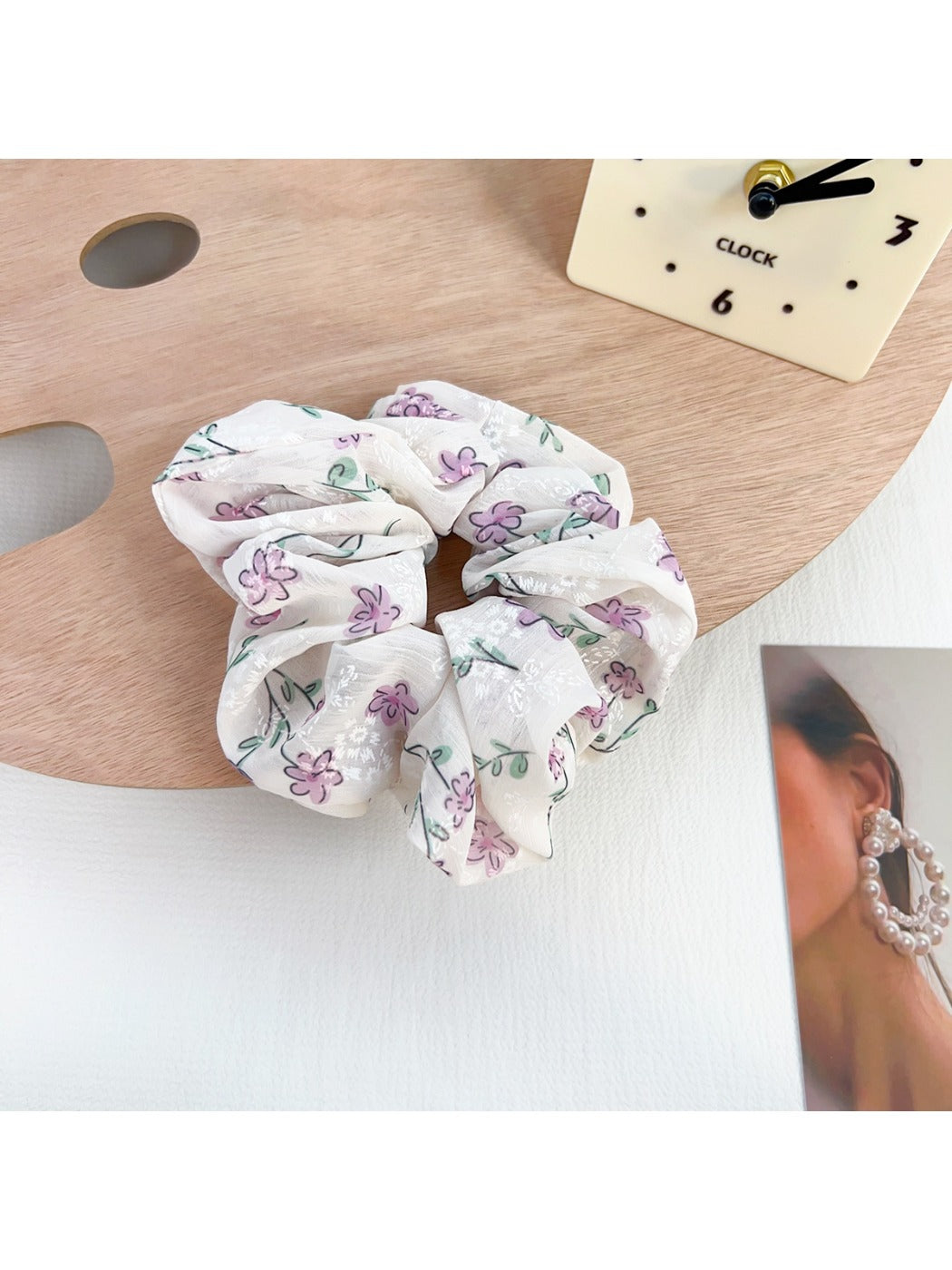 Multiple Gifty floral scrunchies stacked, highlighting ruffled texture and bow accents