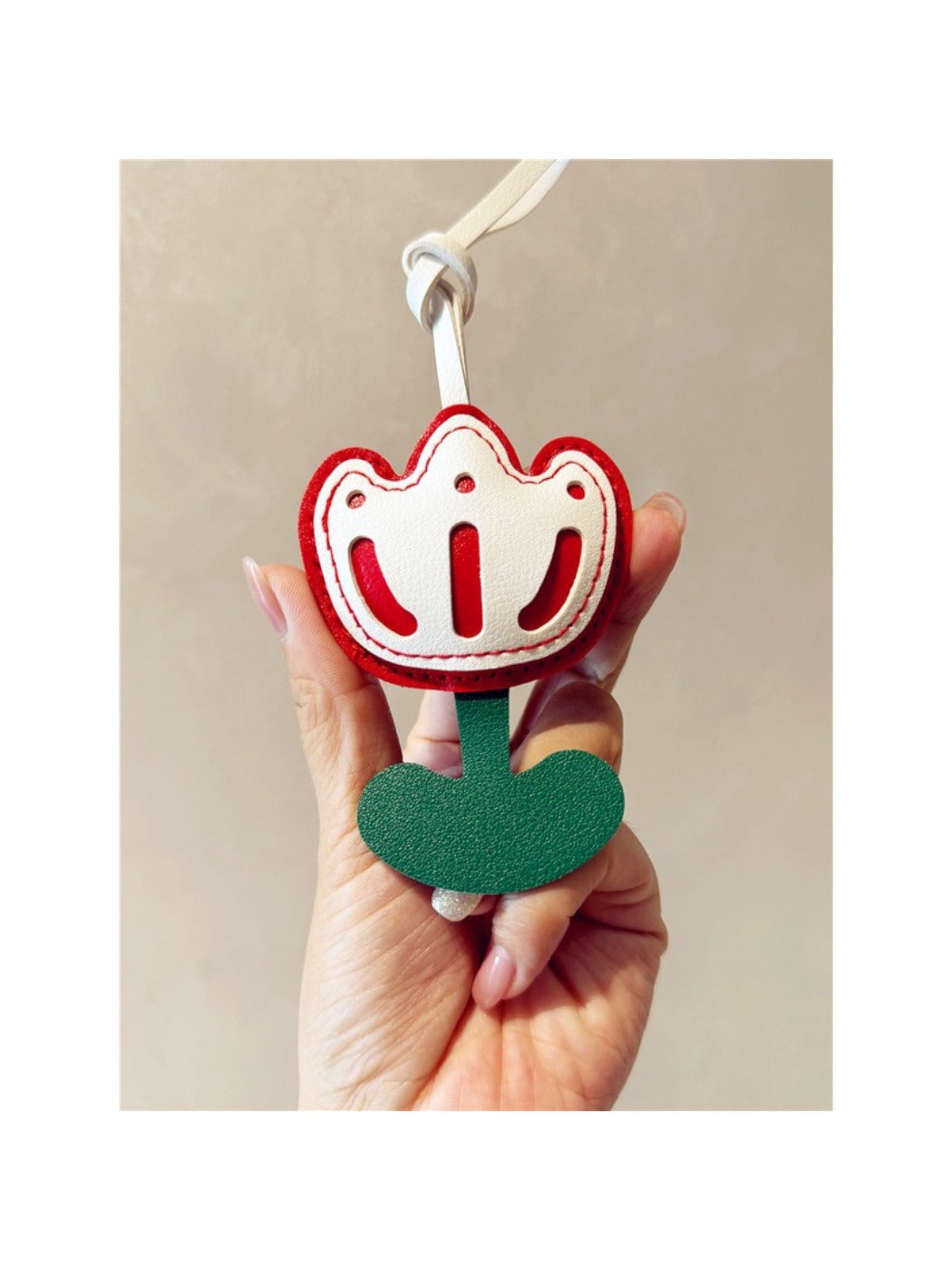 Pink tulip bag charm keychain next to a matching pink wallet