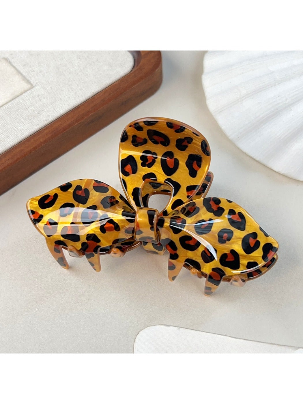 Beau leopard print bow hair claw clip held in hand