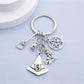 Alloy witch hat keychain with broom charm displayed on a white background