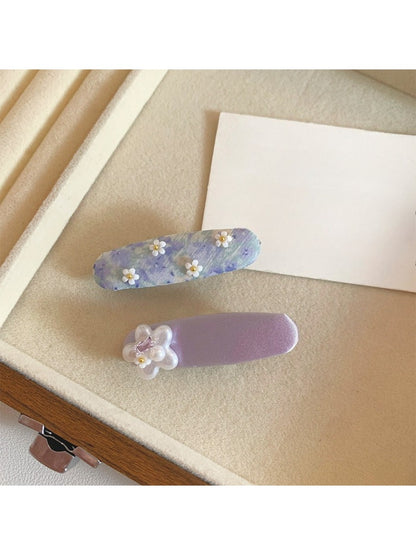 Beau hair clip featuring small purple flowers on a light background