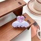 Beau medium heart shaped half circle claw clip next to matching hair accessories