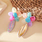 Pair of flower-shaped raffia lace earrings displayed on a white background
