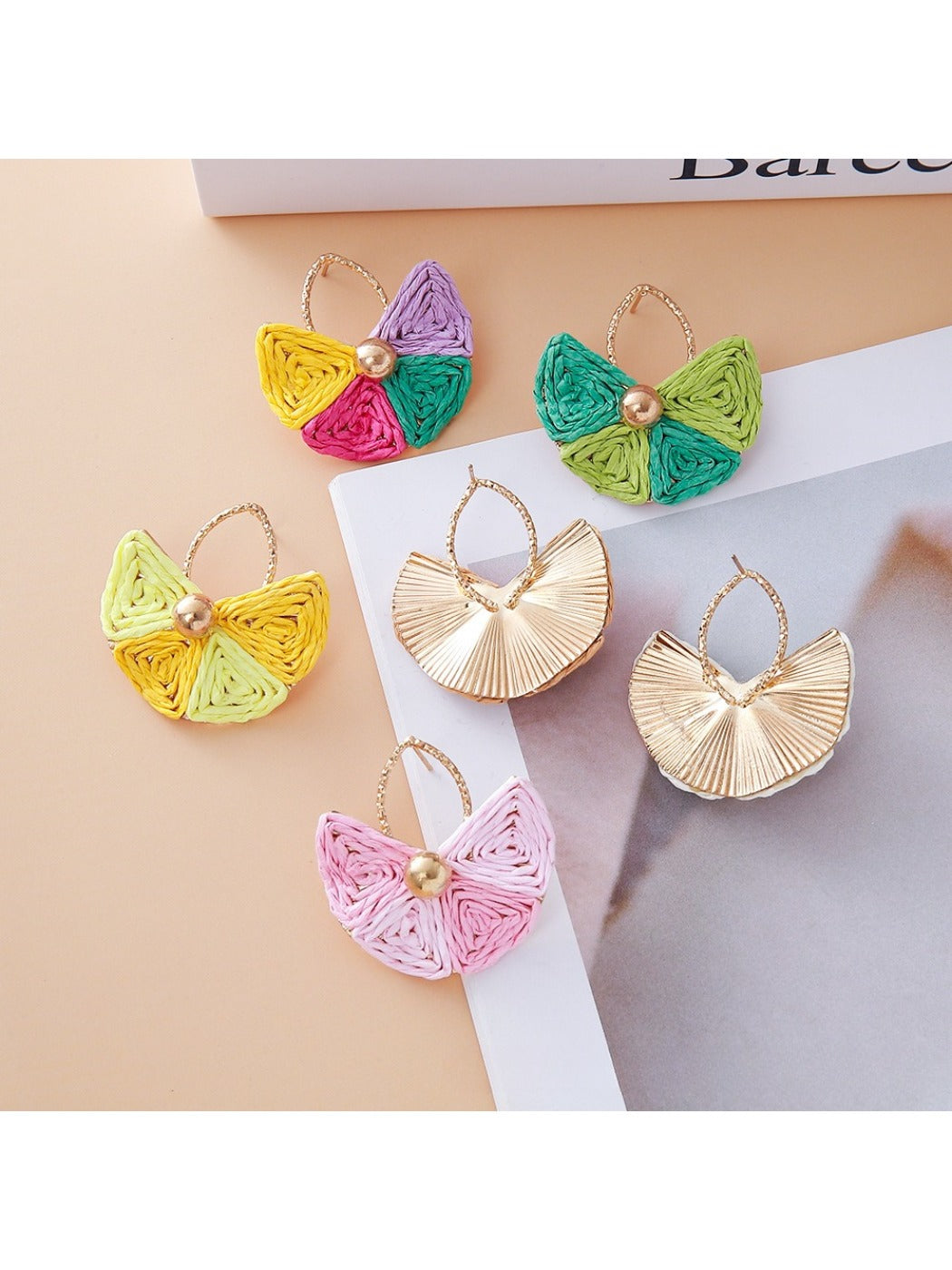 Side view of raffia drop earrings showing woven fan design and gold hooks