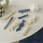 Beau hair clip placed on a wooden surface displaying blue and white colors