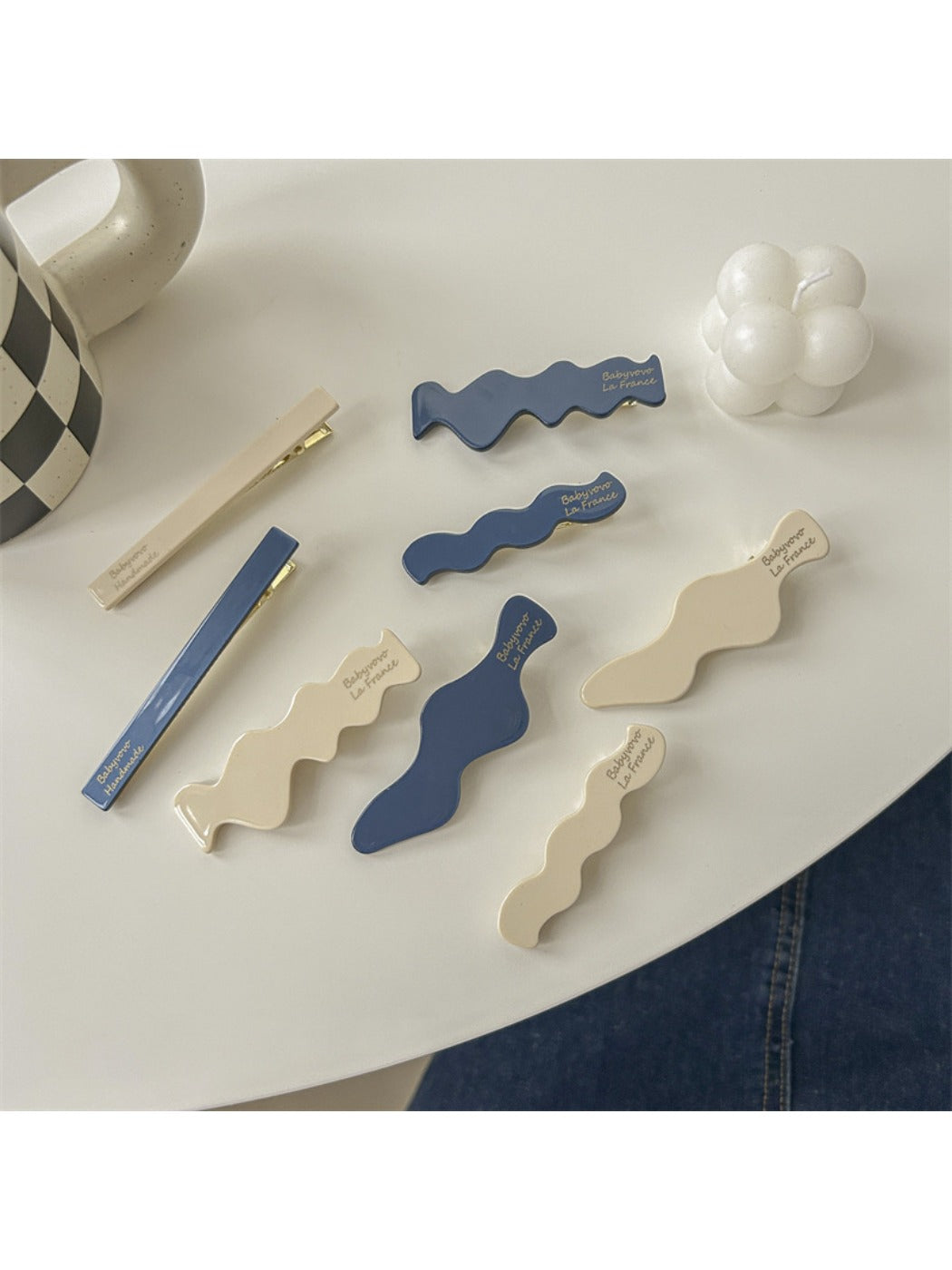 Beau hair clip placed on a wooden surface displaying blue and white colors