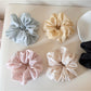 Close-up of Gifty soft polka dot scrunchie in pastel pink fabric with white dots