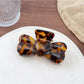 Beau bow shaped hair claw clip styled in a casual half-up hairstyle