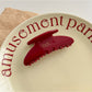 Beau red hair clip positioned on flat surface showing underside clasp mechanism