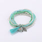Lovra bracelet worn on wrist highlighting layered beads and pink tassel charm