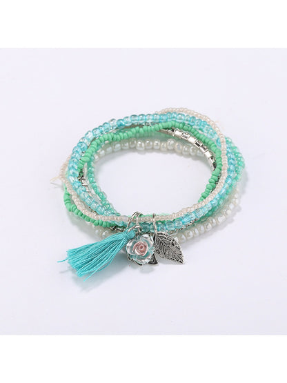 Lovra bracelet worn on wrist highlighting layered beads and pink tassel charm