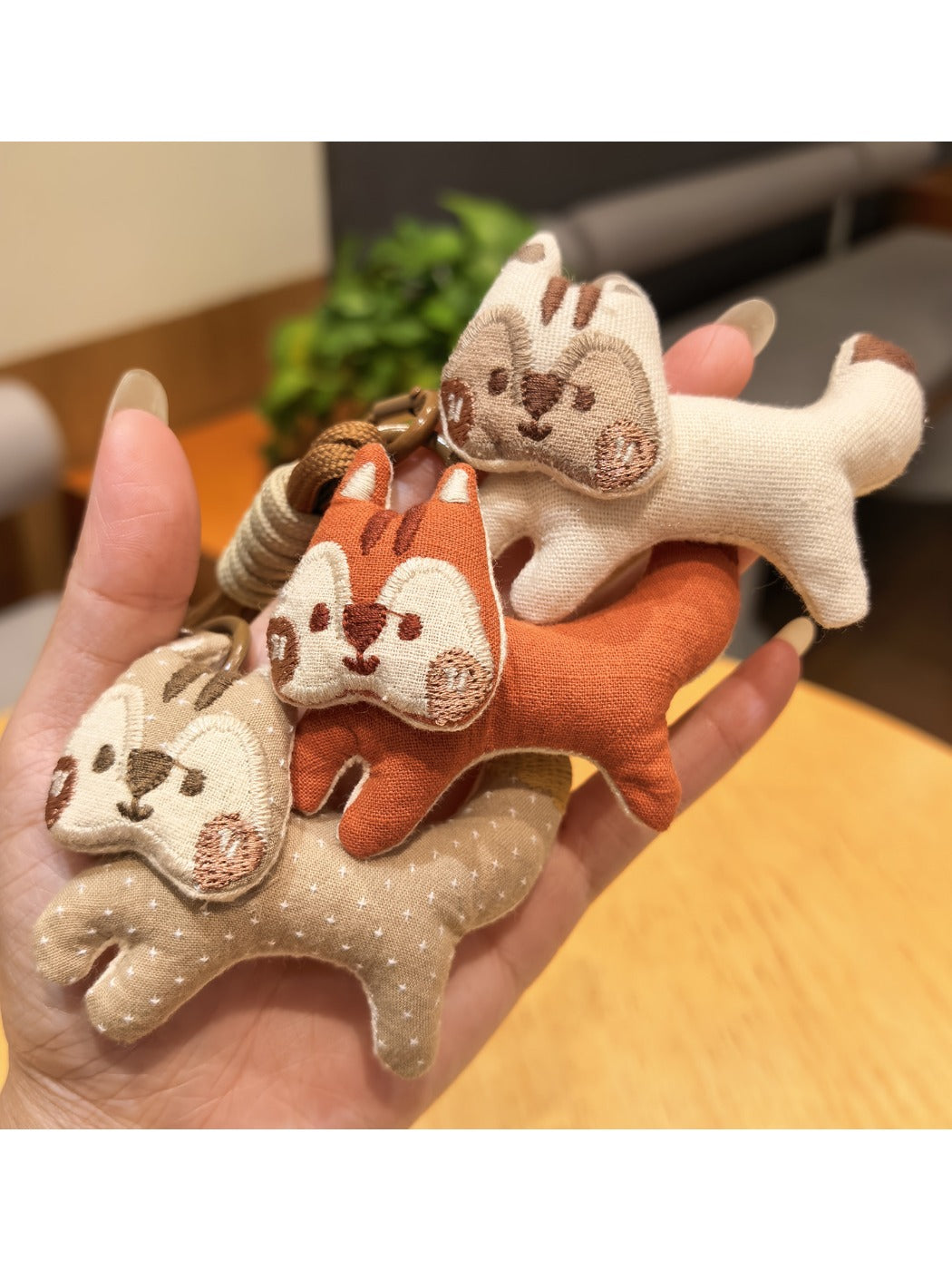 Keypus squirrel charm keychain hanging from a silver keyring on white background