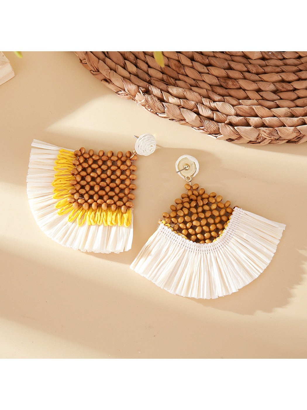 Pair of vintage square raffia drop earrings displayed on a beige fabric surface