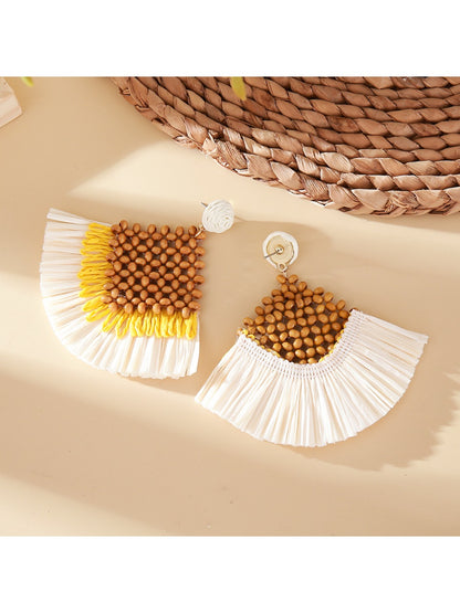 Pair of vintage square raffia drop earrings displayed on a beige fabric surface